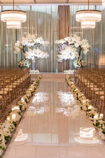 Wedding reception area isle ceremony beautiful white japanese trees adorning the altar with two large circular hanging chandeliers wedding planners park cities events dallas texas
